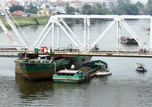 Xà lan kẹt dưới cầu trên sông Sài Gòn