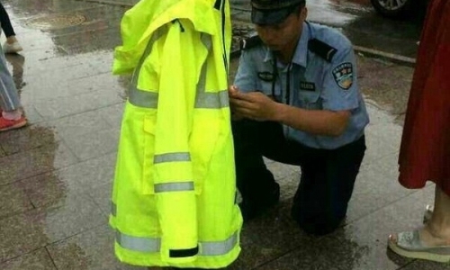 Cảnh sát dầm mưa nhường áo bảo hộ cho em bé đi lạc khiến hàng triệu trái tim tan chảy
