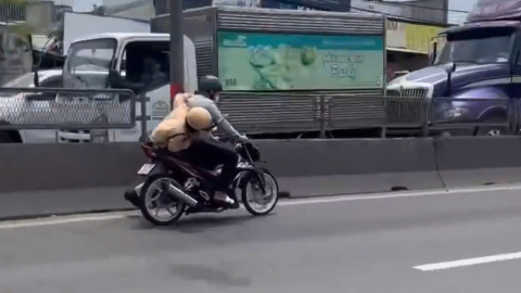 CSGT bám vào xe máy đang chạy trên Quốc lộ 1, huyện Bình Chánh