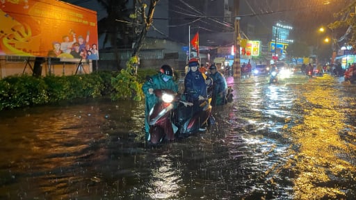 TP.HCM mưa lớn, nhiều người dân khổ sở dắt xe máy trong dòng nước cuồn cuộn