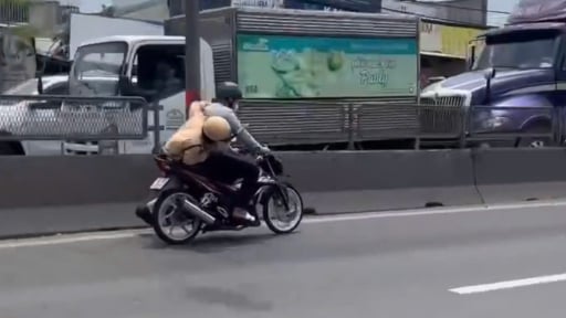  CSGT bám vào xe máy đang chạy trên Quốc lộ 1, huyện Bình Chánh