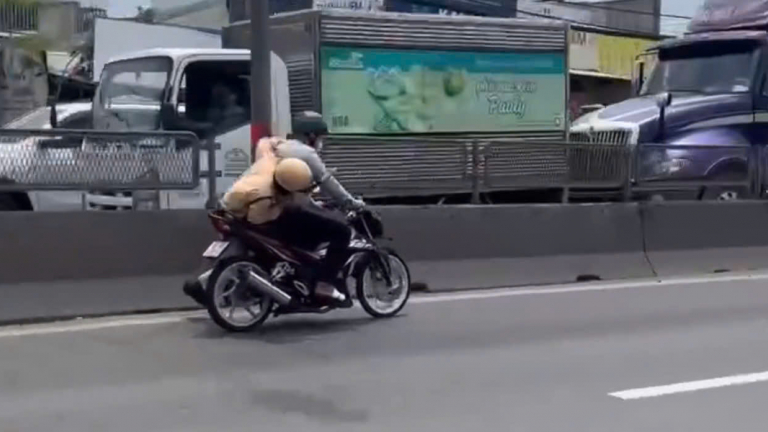  CSGT bám vào xe máy đang chạy trên Quốc lộ 1, huyện Bình Chánh