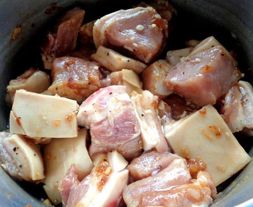 Thịt lợn rửa sạch, thái miếng vừa ăn và ướp cùng tỏi, hành băm và nước mắm