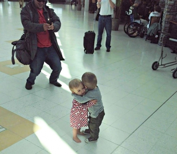 Hai đứa trẻ xa lạ quấn quít nhau ở sân bay
