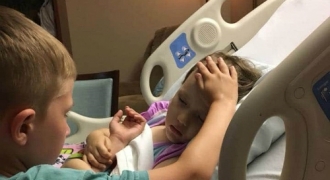 Xúc động hình ảnh cậu bé 6 tuổi vuốt trán an ủi em gái sắp qua đời vì ung thư não
