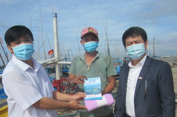 Ông Hà Viên, Giám đốc Ban Quản lý cảng cá Phú Yên và đại diện Báo Nông nghiệp Việt Nam gửi đến ngư dân sổ tay và quà tặng của dự án. Ảnh: Đặng Thăng.