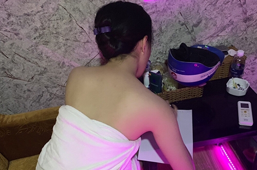 Nữ nhân viên ngực trần massage cho khách ở phố Tây Sài Gòn