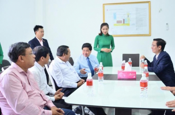 Deputy Minister of Agriculture and Rural Development Lê Quốc Doanh, the fourth from the left, talks with leaders of Vina T&T Group at the packaging factory in the southern province of Bến Tre. Photo: Minh Đảm.