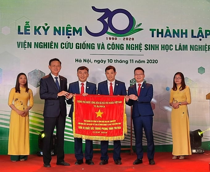 Standing Deputy Minister of Agriculture and Rural Development Ha Cong Tuan awarded the Government's Emulation Flag to the Forest Tree Improvement and Biotechnology Research Institute on its 30th anniversary. Photo: Nguyen Huan.