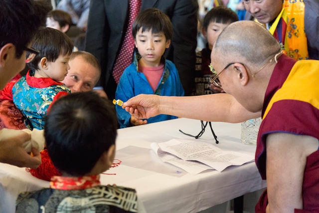 Đức Đạt Lai Lạt Ma cho kẹo và chúc Phúc Cát tường cho trẻ em sau buổi Pháp, vào ngày đầu tiên, trong chuyến thăm ba ngày của đức Đạt Lai Lạt Ma tại Thủ đô Copenhagen, Đan Mạch. 10/02/2015. (Ảnh: Mugge Lui)