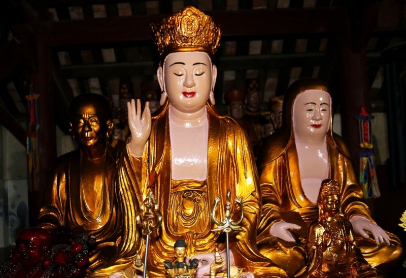 Hai gian bên cạnh thờ tổng hợp tượng Phật và tượng thánh thần. Phía trước gian bên phải thờ 3 pho tượng lớn được cho là tượng Bồ tát, tổ sư… Ảnh: Huy Thư