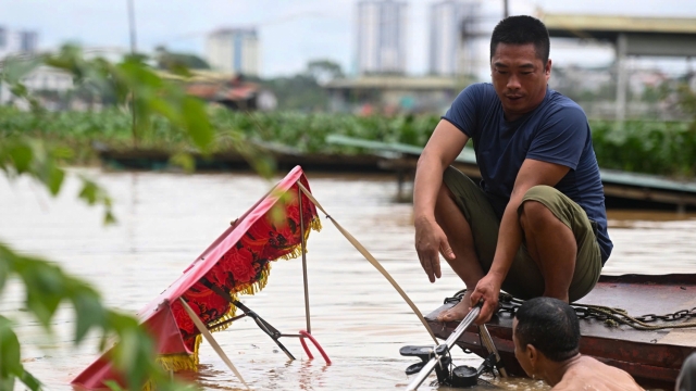 Người dân ngoài đê sông Hồng di dời đồ đạc khỏi nước lũ