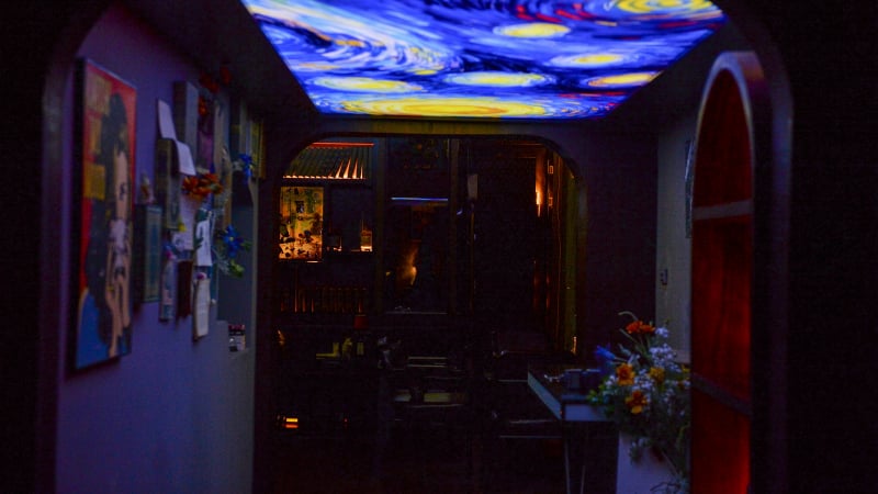 Thưởng cocktail trong ánh sáng mờ, dưới nền tranh của Van Gogh