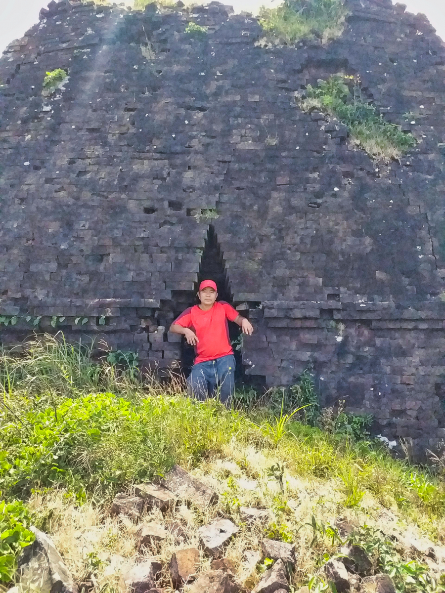 Anh Lê Thanh trước cửa ngôi tháp trên đỉnh Hòn Chuông, phía trước là ngổn ngang gạch cũ (Ảnh: Lê Thanh)