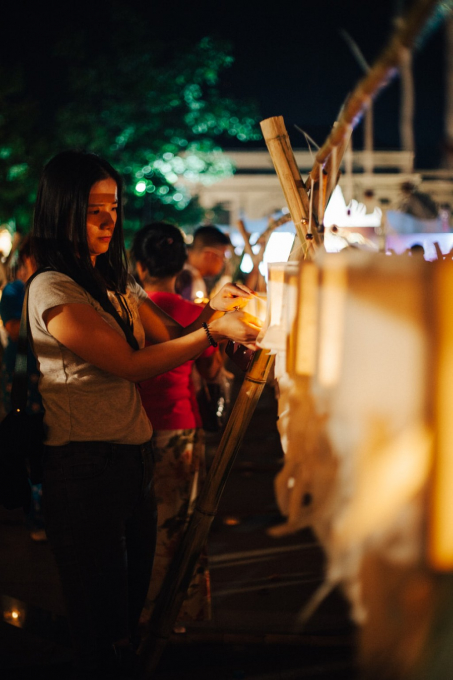 Một phụ nữ Thái Lan đang thắp đèn lồng tại Đài tưởng niệm Tam vương