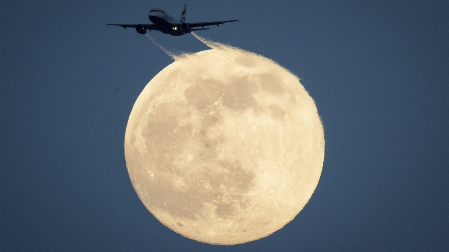 London, Anh: Một chiếc máy bay bay qua mặt trăng. Bức ảnh được chụp tại công viên Richmond, tây nam London, vào ngày 8/2. (Aaron Chown)