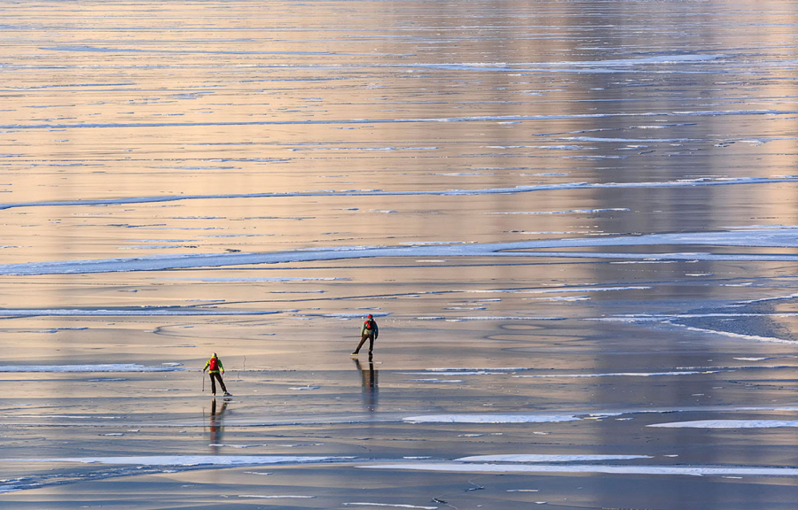 Hai du khách chơi trò trượt băng trên hồ