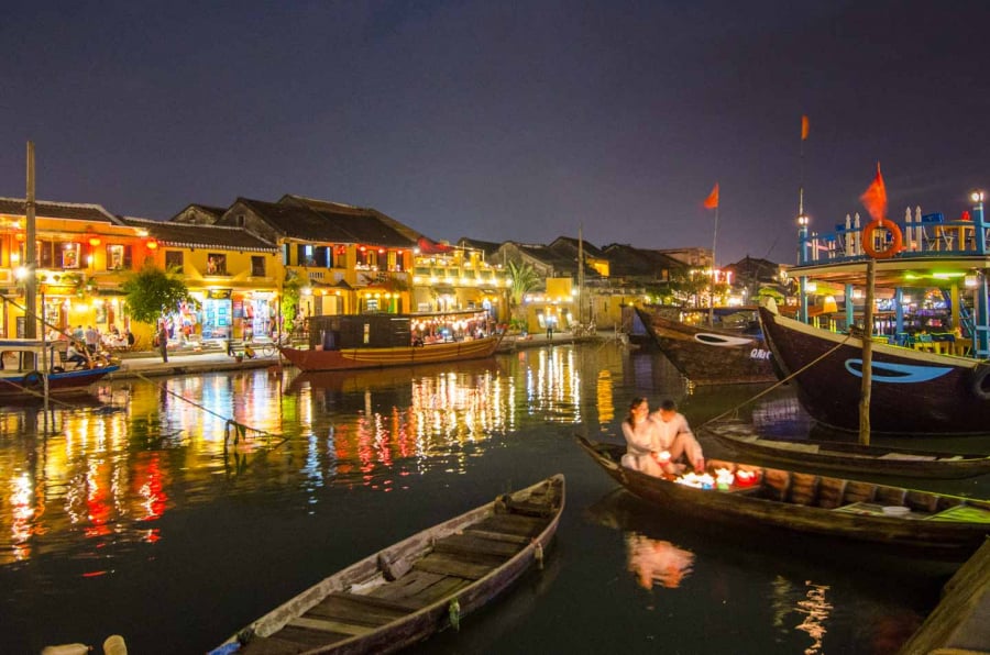 A-couple-on-a-boat-lighting-lanterns-Hoi-An-full-moon-Lantern-Festival