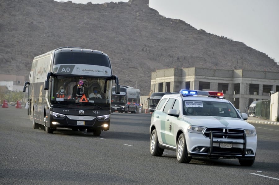Một xe cảnh sát hộ tống đoàn người hành hương đến Đại Thánh đường