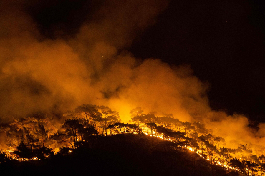 Sau suốt một đêm cố gắng, lính cứu hoả đã kiểm soát được ngọn lửa lan gần đến một nhà máy điện ở Milas thuộc tỉnh Mugla, Hy Lạp. (Ảnh: Yasin Akgul/Agence France-Presse - Getty Images)