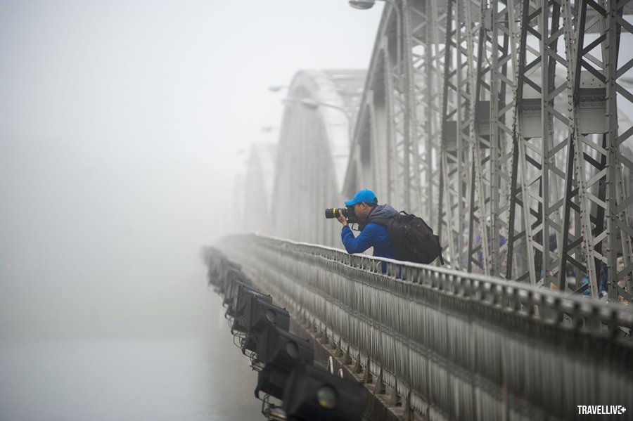 Nhiếp ảnh gia say mê tác nghiệp trên chiếc cầu 