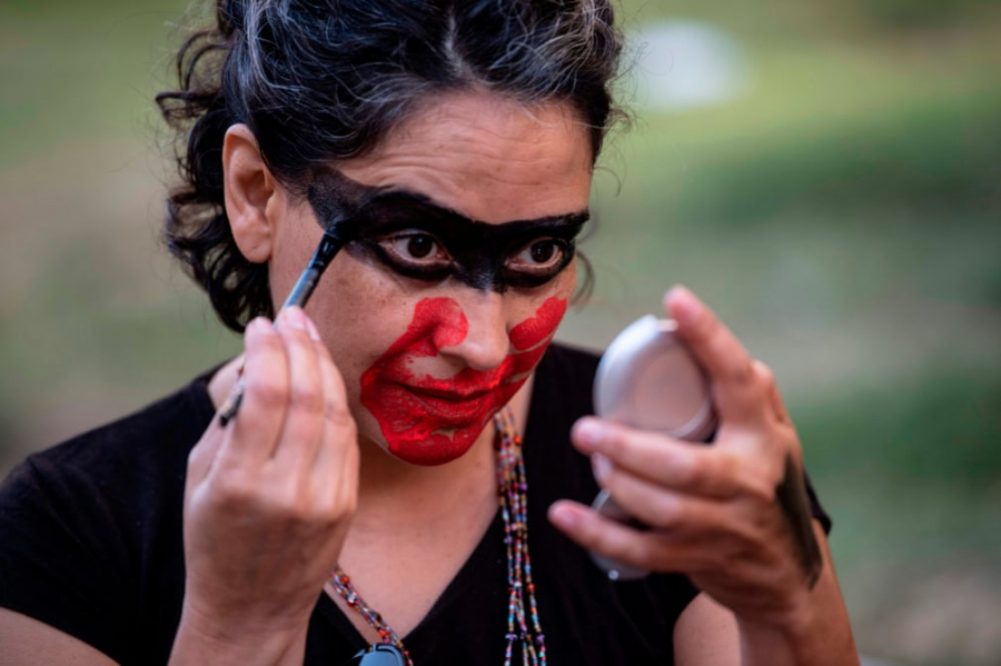 Một phụ nữ Chile vẽ mặt với biểu tượng bàn tay bịt miệng trong một cuộc biểu tình