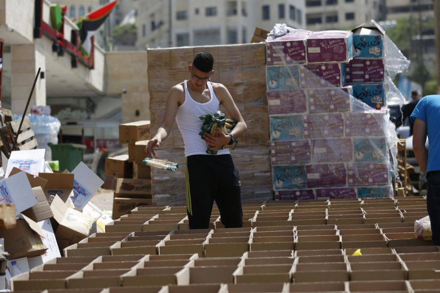 Một người đàn ông sống tại thành phố Nablus ở Bờ Tây đóng gói các hộp đựng thực phẩm sẽ được phân phát cho các gia đình nghèo ở Palestine trước tháng chay Ramadan