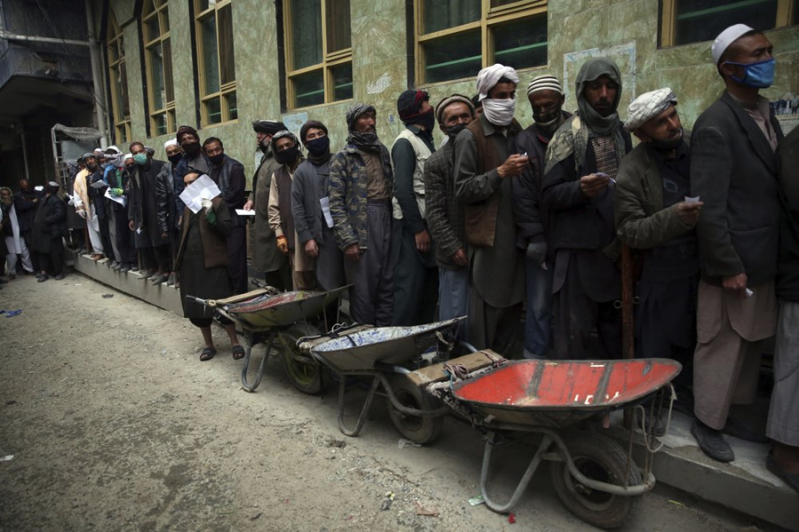 Những công nhân nghèo xếp hàng để nhận lúa mì miễn phí trước tháng chay Ramadan ở Kabul, Afghanistan ngày 20/4