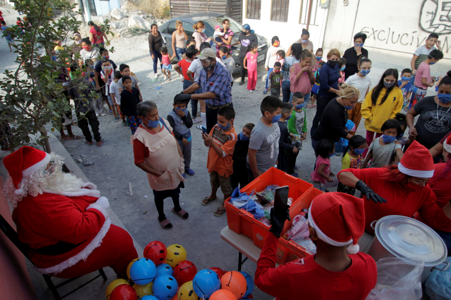 Trẻ em xếp hàng để nhận quà Giáng sinh từ thiện nguyện viên hóa trang làm ông già Noel ở Monterrey, Mexico ngày 22/12