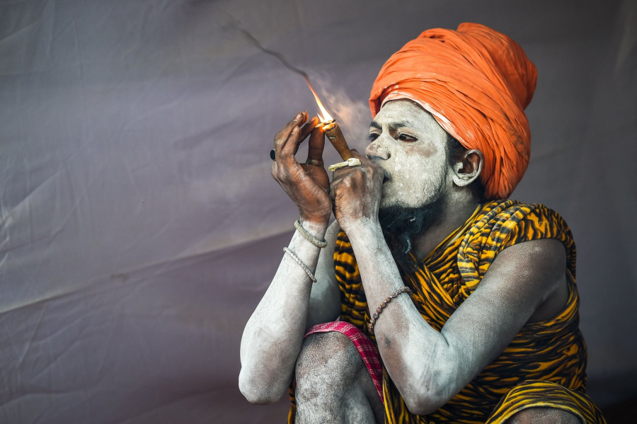 Một Sadhu hút thuốc trong lều của mình. Rất nhiều naga sadhus, hay những tu sĩ khổ hạnh, những người tôn thờ Shiva đang nằm trong sự quản giáo của các của tu viện và một số người sống trong các hang động xa xôi.