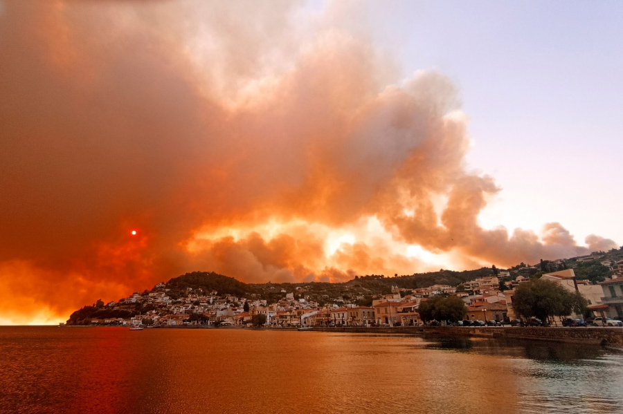 Những ngọn núi gần làng Limni, trên đảo Evia, chìm trong biển lửa. Trong bức ảnh được chụp lại, gần như không thể nhìn thấy mặt trời qua làn khói dày đặc phủ bên trên những ngôi nhà bên vách đá. (Ảnh: Michael Pappas/Associated Press)