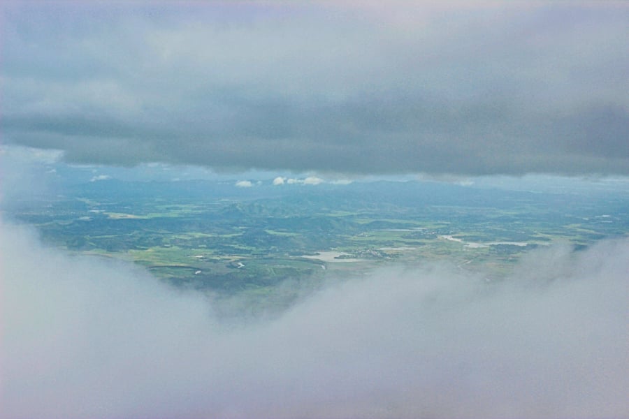 Một góc đồng bằng phía dưới hiện ra trong khoảnh khắc giữa “lỗ thủng” của biển mây