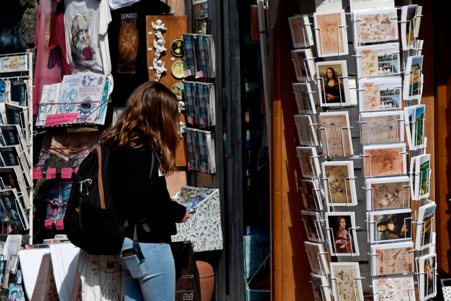 Một khách du lịch đang ngắm nghía các vật phẩm ở hàng lưu niệm mang đậm dấu ấn Leonardo da Vinci