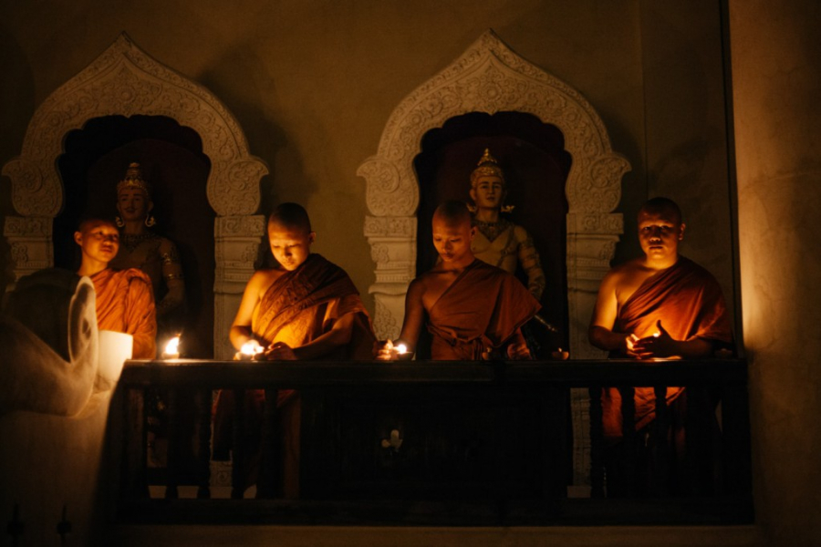 Bốn nhà sư thắp nến ngoài một ngôi chùa
