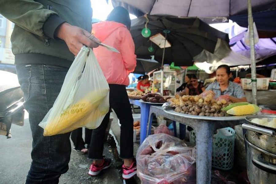 Một vị khách mua ngô luộc được người bán hàng đựng bằng túi nilon sinh học