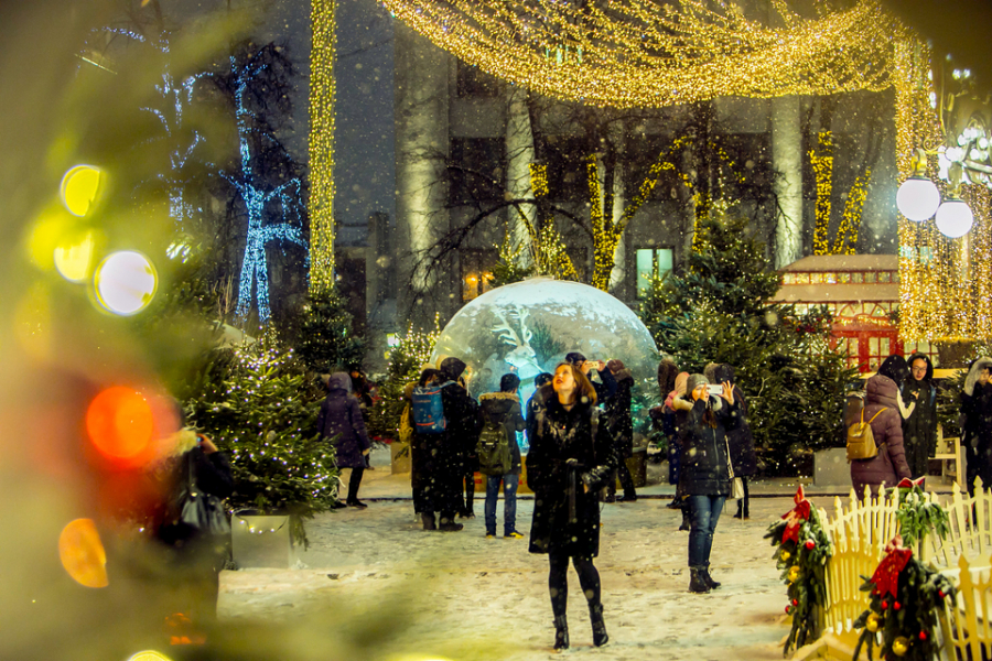 Cô gái trẻ ngắm nhìn những bông tuyết rơi trong không gian lễ hội cuối năm ở thành phố Moscow.