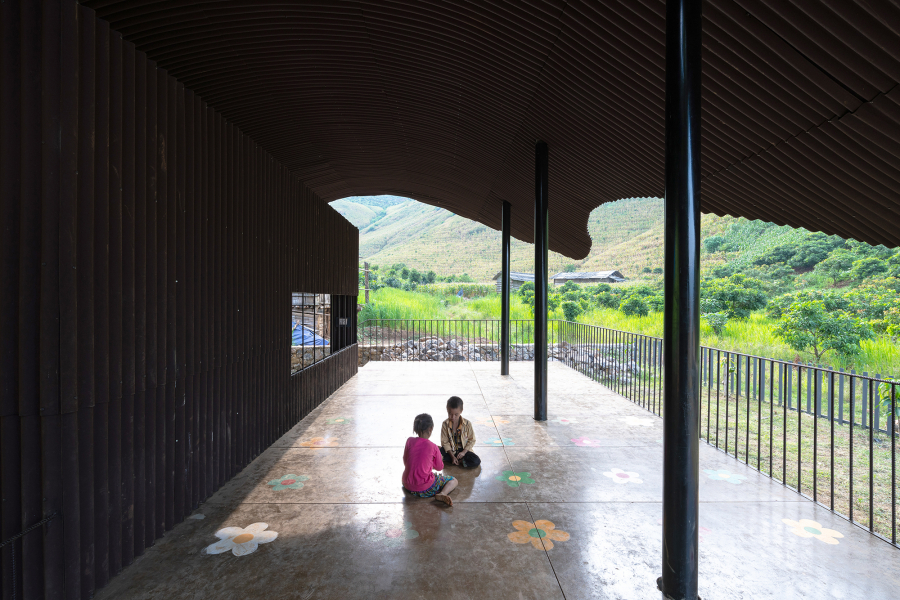 Phần sân trung tâm này được thiết kế như một sân mở đa chức năng bên dưới một mái hiên mát mẻ, nơi trẻ con chơi đùa với nhau