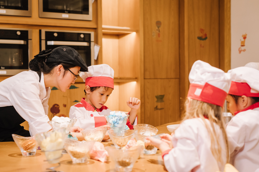Các bé tham gia hoạt động tập làm đầu bếp với trò nhào bột làm bánh tại khu vực Kids Can Cook