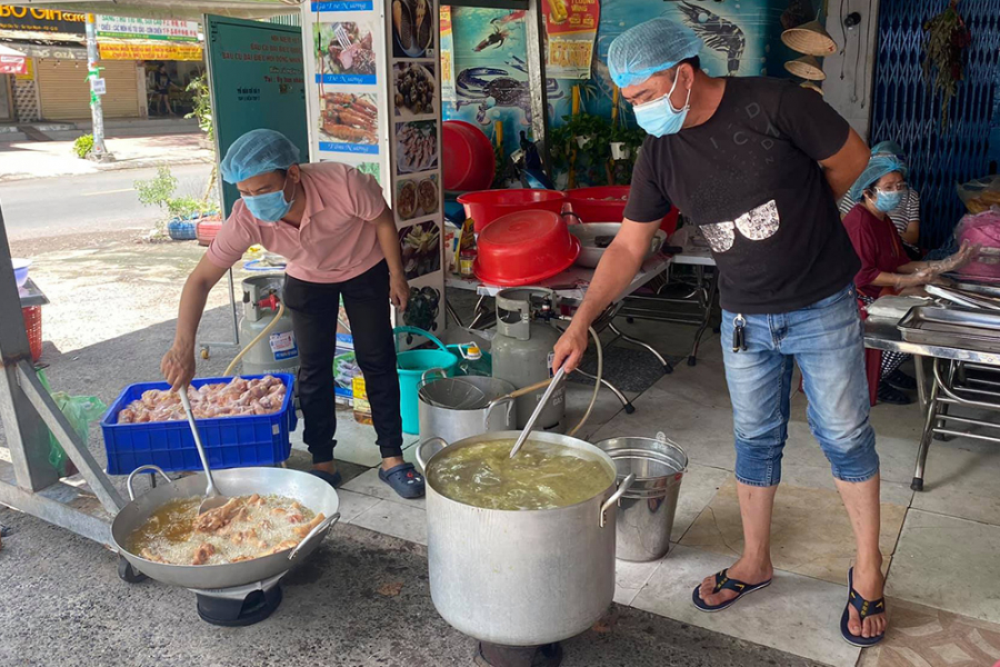 Nhóm bếp của nghệ sĩ Hữu Quốc chuẩn bị các suất ăn cho người nghèo. 