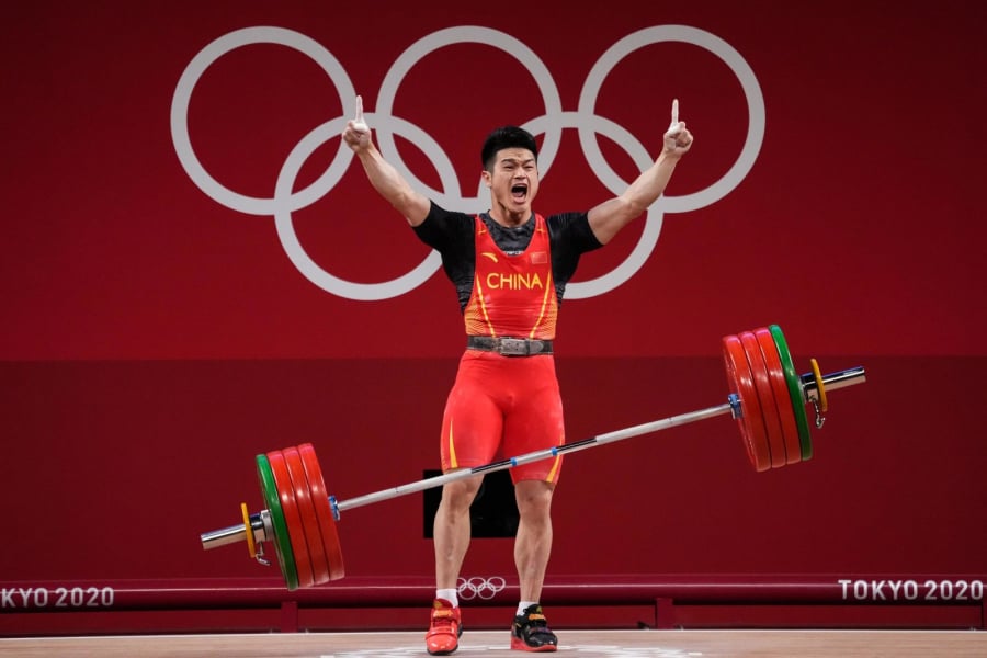 VĐV cử tạ người Trung Quốc Shi Zhiyong ăn mừng sau khi giành HCV hạng cân 73 kg. Anh đã nâng được 166 kg ở nội dung cử giật và 198 kg ở nội dung cử đẩy, lập kỷ lục thế giới mới với tổng số 364 kg.