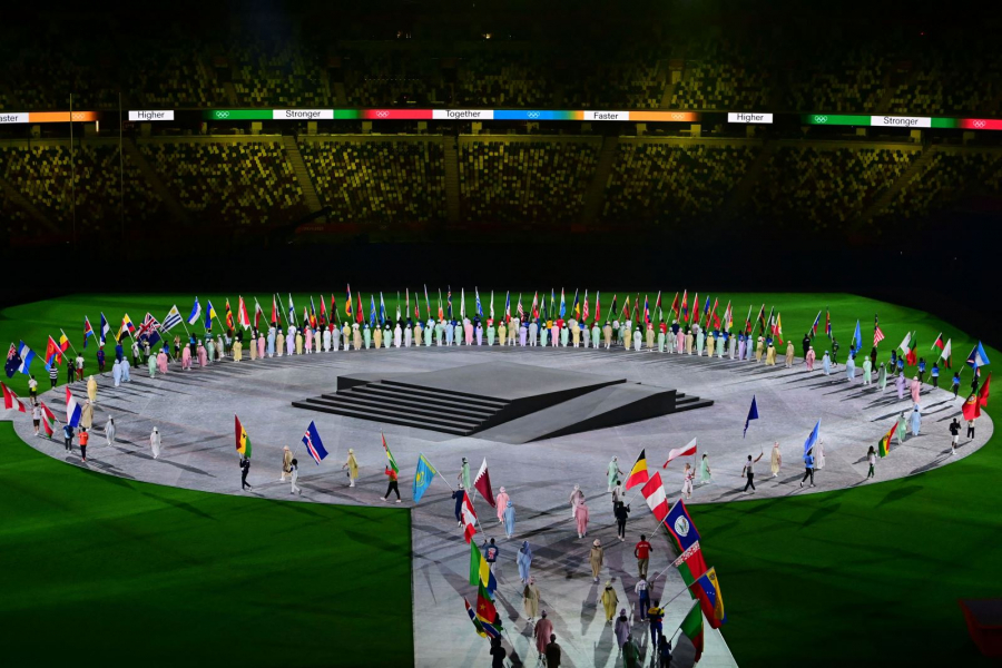 Đại diện các đoàn thể thao cầm quốc kỳ tiến vào trung tâm sân vận động Olympic.
