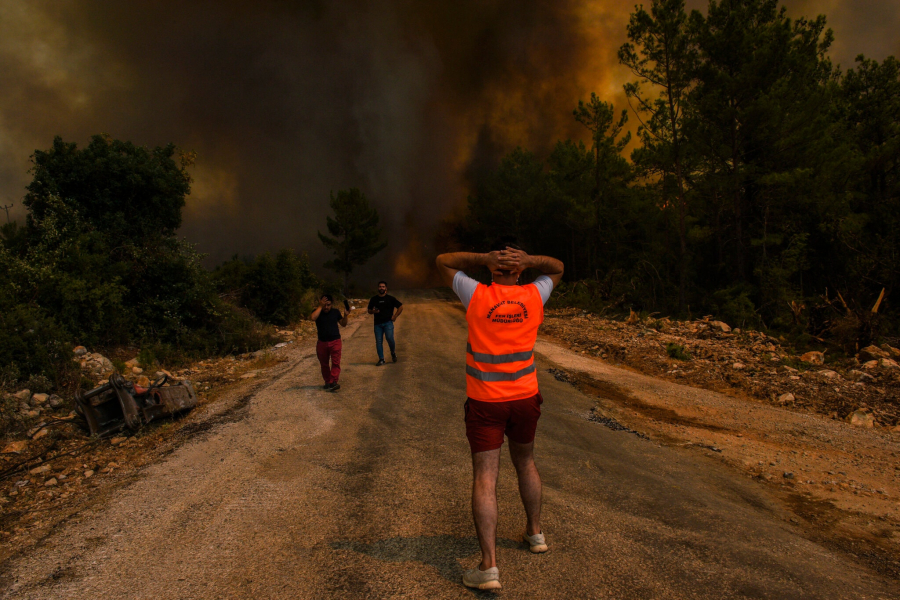 Người dân rời bỏ ngôi làng bị tàn phá bởi lửa ở Sirtkoy, Thổ Nhĩ Kỳ. (Ảnh: Associated Press)