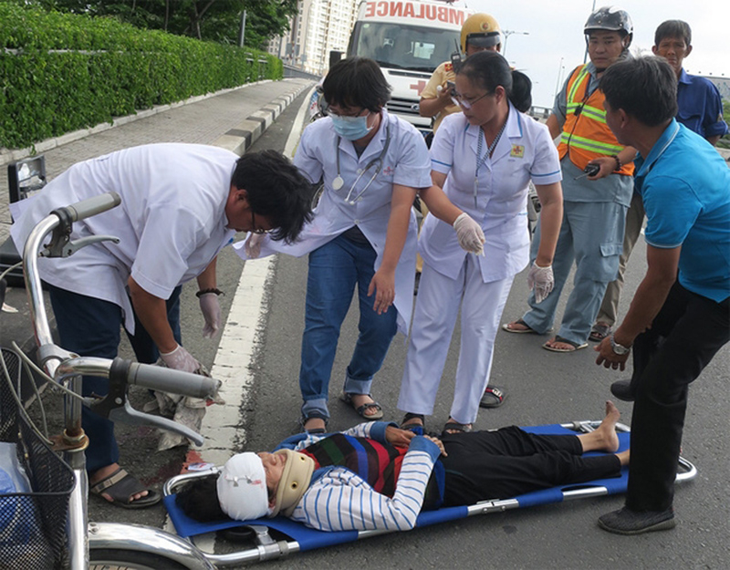 Nhân viên cấp cứu ngoại viện sơ cứu cho nạn nhân bị tai nạn giao thông ở Q.1, TP.HCM - Ảnh dangcongsan