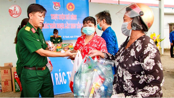 Đoàn thanh niên Công an tỉnh Hậu Giang trao quà cho người lao động nghèo đến đổi rác lấy gạo.