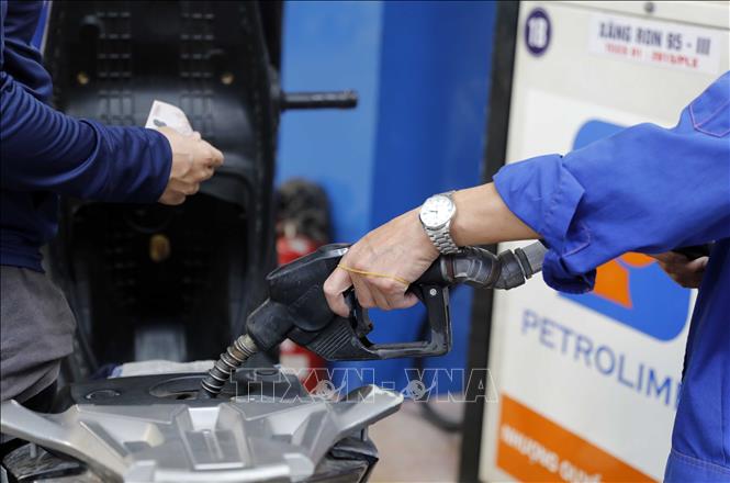 Mua, bán xăng tại một điểm kinh doanh xăng, dầu của Petrolimex ở Hà Nội (Ảnh: TTXVN)