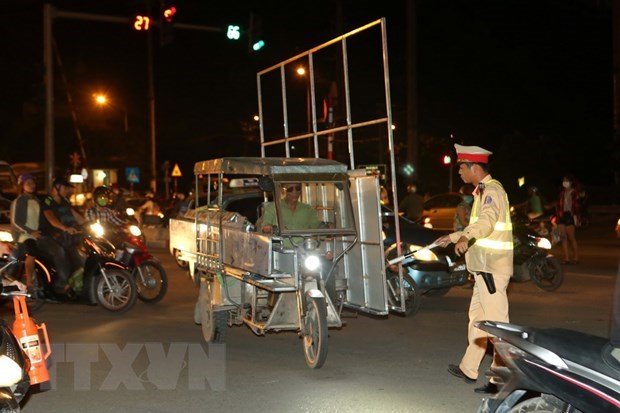 Cảnh sát giao thông Đội 14, Công an thành phố Hà Nội xử lý người điều khiển chở hàng quá khổ tại đường Giải Phóng, Hà Nội. Ảnh: Doãn Tấn/TTXVN