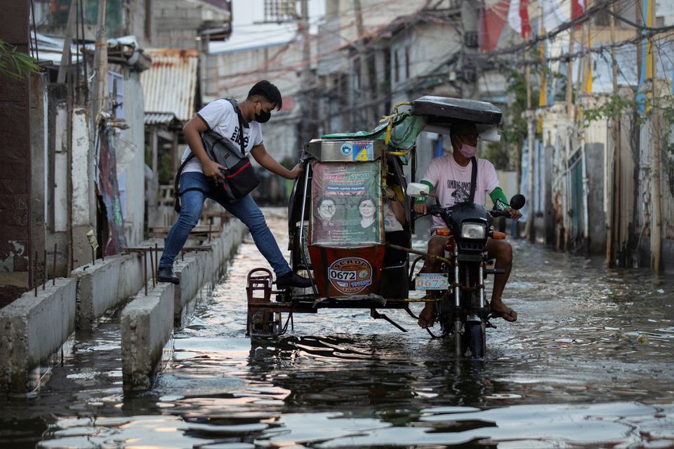 Những chiếc taxi 3 bánh được 'độ' lại để có thể di chuyển trong tình trạng ngập nước ở thị trấn Hagonoy, Philippines. Ảnh: Reuters
