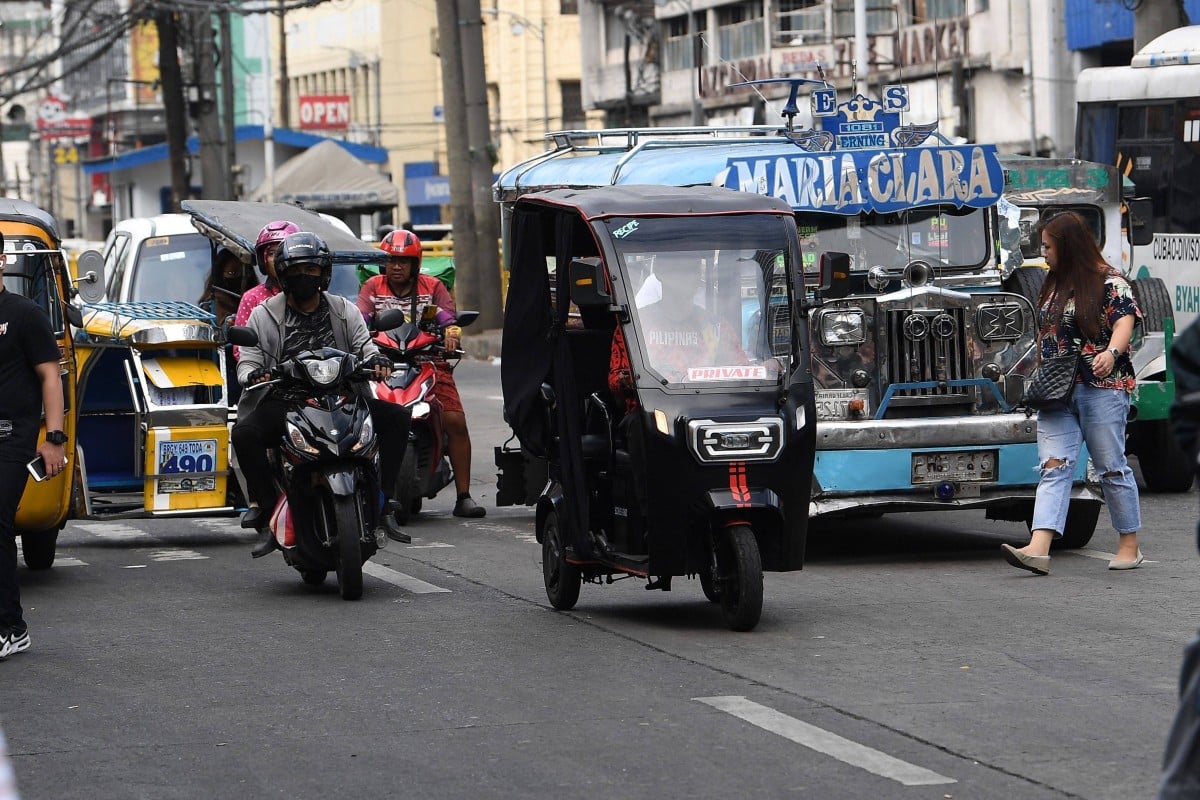 Một chiếc xe ba bánh điện chạy qua đường phố ở Manila. Ảnh: AFP