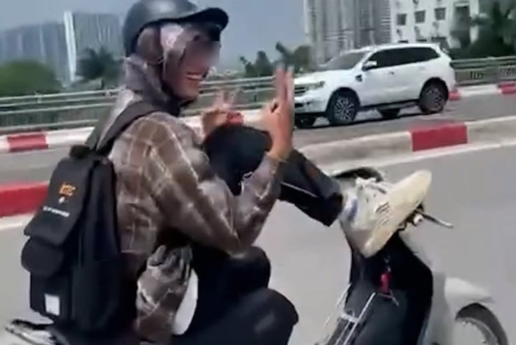 Nam tài xế dùng chân điều khiển xe máy với tốc độ khá cao và tỏ ra thích thú khi thực hiện hành động nguy hiểm