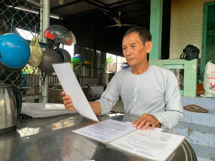 Ông Trần Văn Út xem lại từng quyết định thành lập các tổ từ thiện ông từng tham gia. (Ảnh: Người lao động)